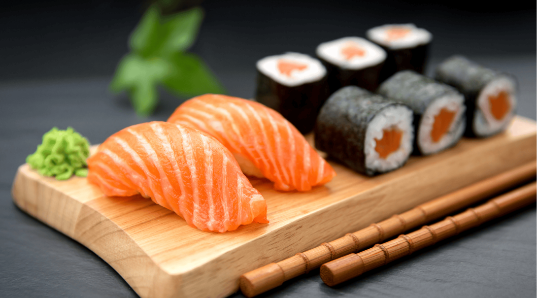 Japanese salmon nigiri and hosomaki sushi on a traditional wooden board